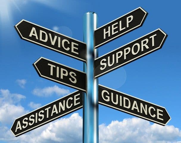 Signpost with six arrows against a blue sky, labeled "Advice," "Help," "Support," "Tips," "Guidance," and "Assistance," symbolizing direction and guidance.