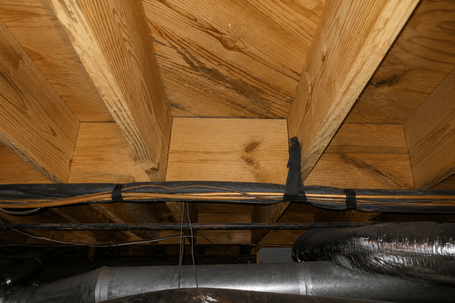 Basement ceiling with wooden beams and ducts