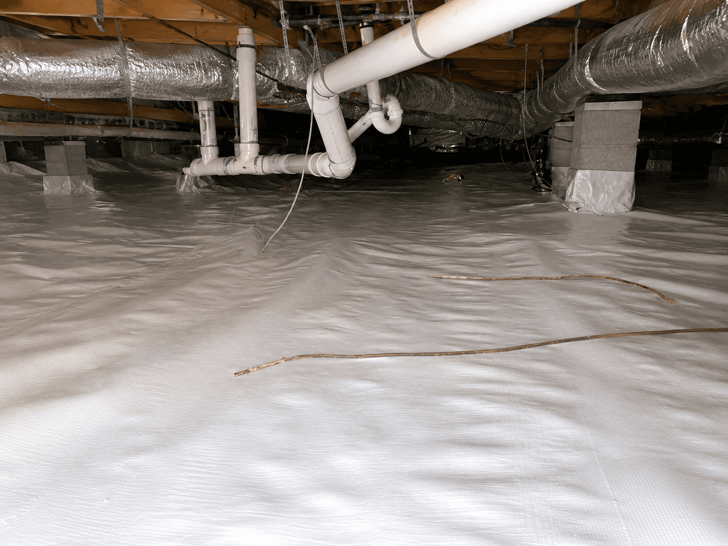 Crawl space with plumbing and ducts