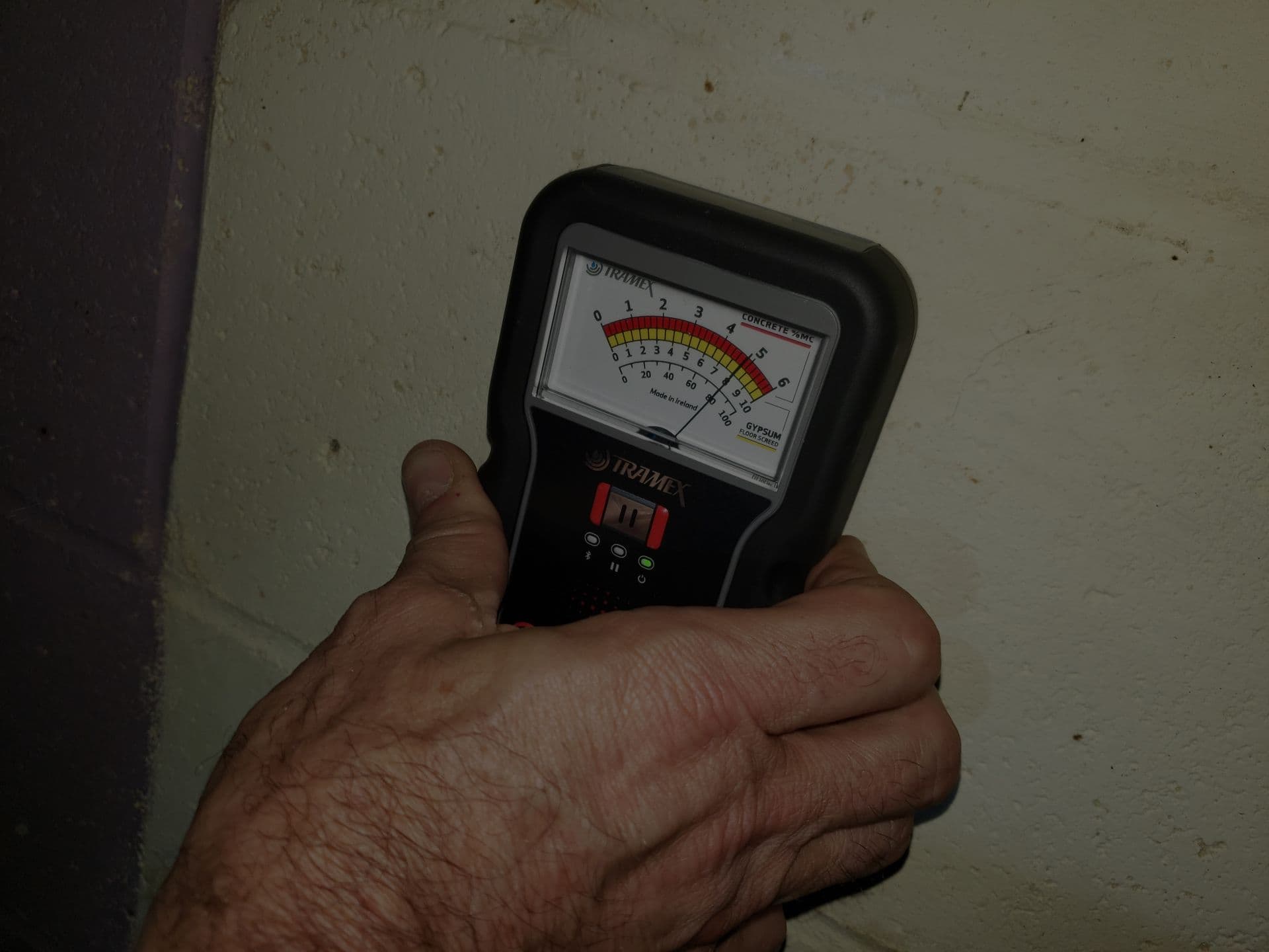 Man testing mold levels on wall